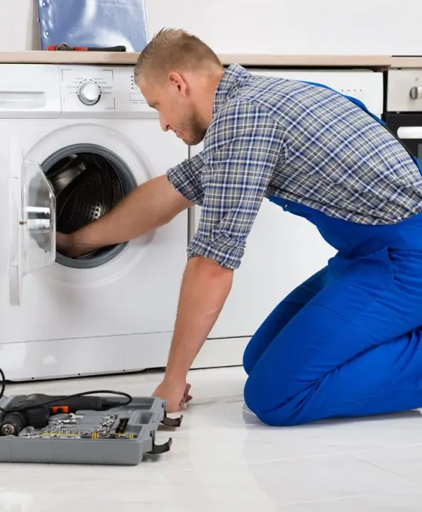 Professional technician repairing a dryer heating element and inspecting the drum system