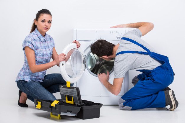 Professional appliance repair technician servicing a front-load washing machine for a homeowner in Gainesville, Florida