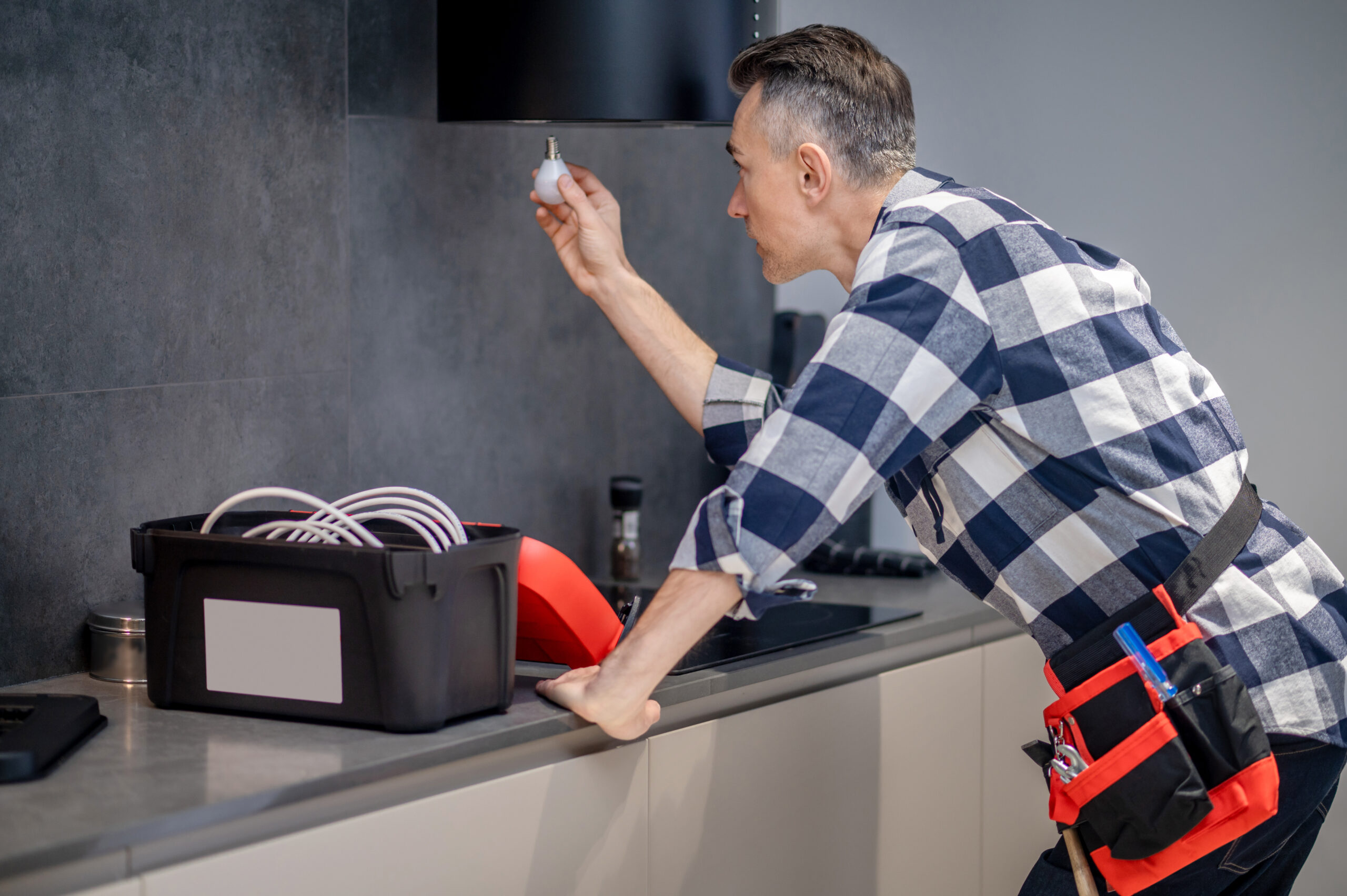 Appliance repair technician inspecting the interior light of a household refrigerator
