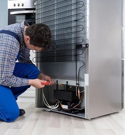 Professional kitchen setting with a modern refrigerator being inspected or repaired in Gainesville FL